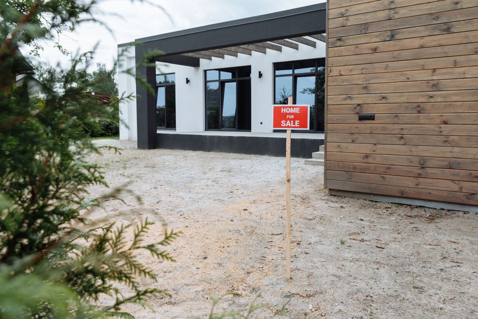 Modern house for sale sign in front yard