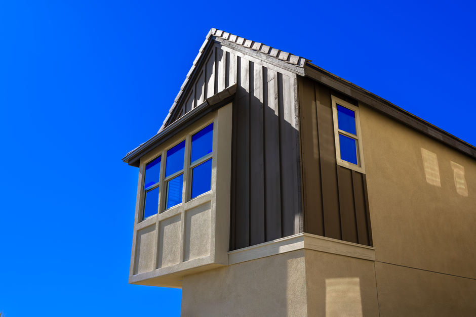 Low angle shot of a modern residential building facade against a clear blue sky